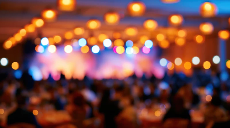 Blurred interior of a crowded banquet hall with warm bokeh lights overhead