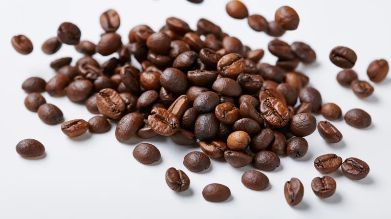 Roasted coffee beans scattered midair on white background