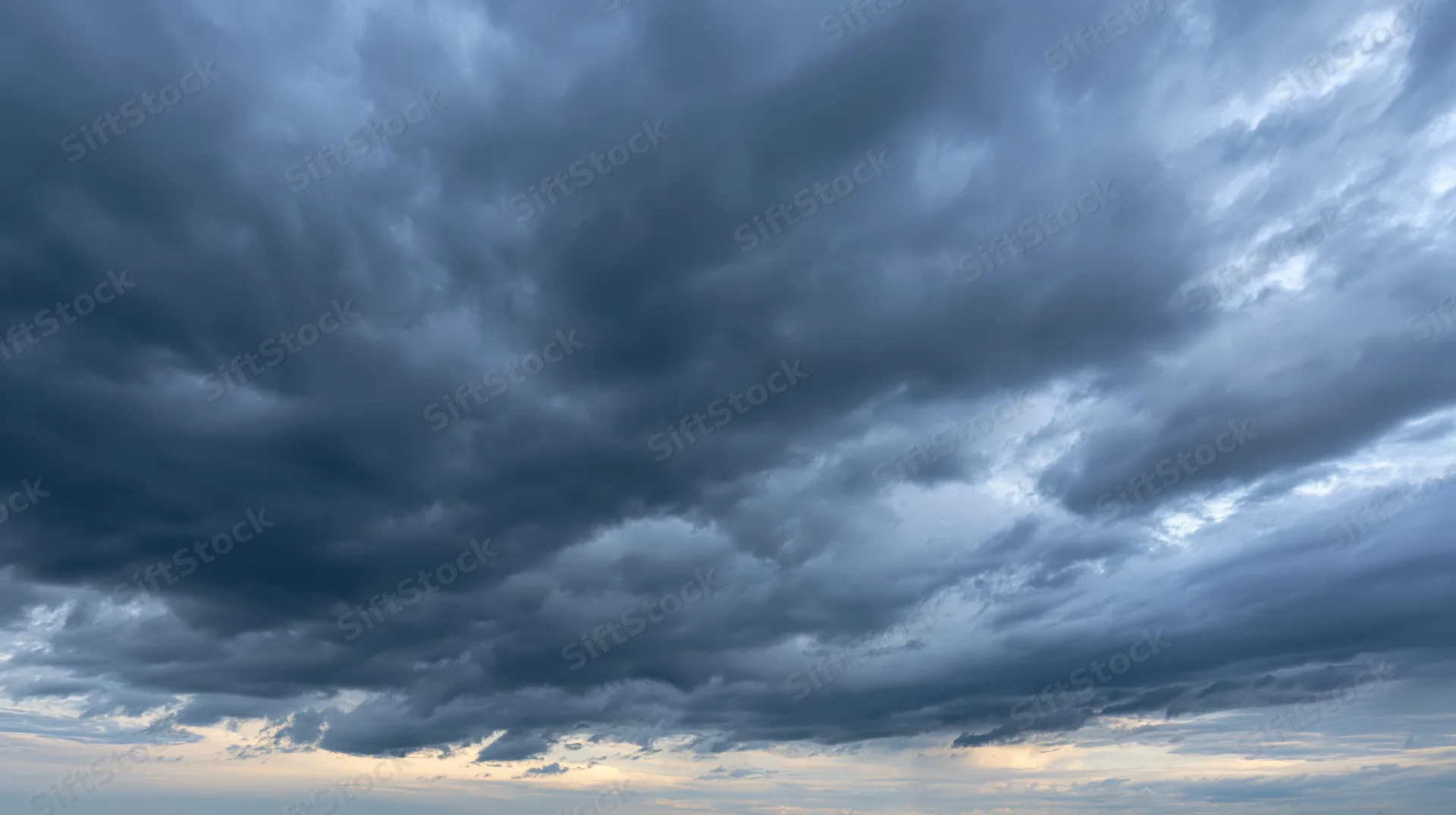 Dramatic stormy sky filled with dark cumulonimbus clouds at twilight