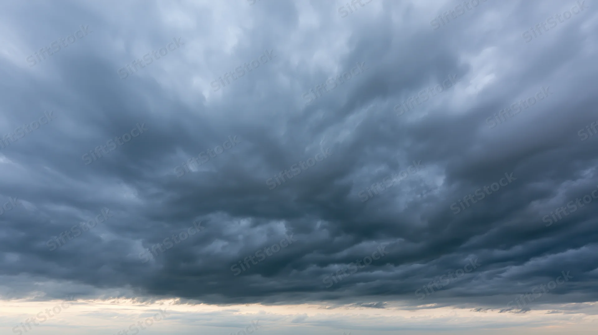 Dramatic stormy sky filled with dark cumulonimbus clouds at twilight