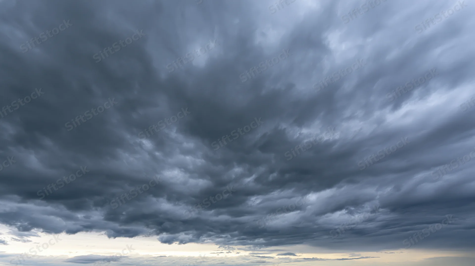 Dramatic stormy sky filled with dark cumulonimbus clouds at twilight