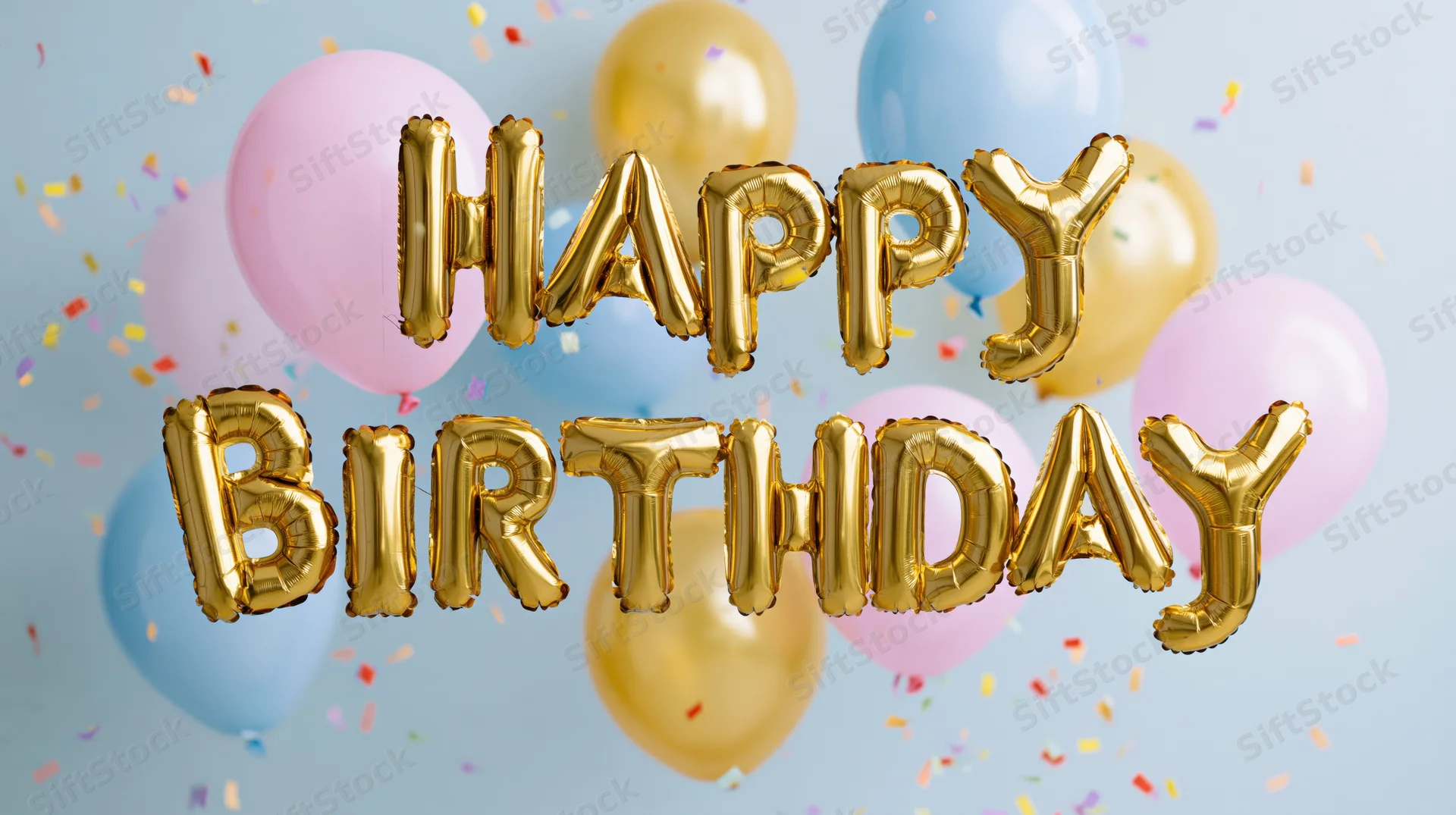 Gold foil letter balloons spelling happy birthday floating among pastel balloons and confetti