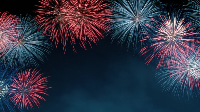 Red, white and blue fireworks bursting across a dark night sky with copyspace below