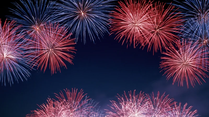 Red and blue fireworks bursting across a dark night sky in a celebratory display