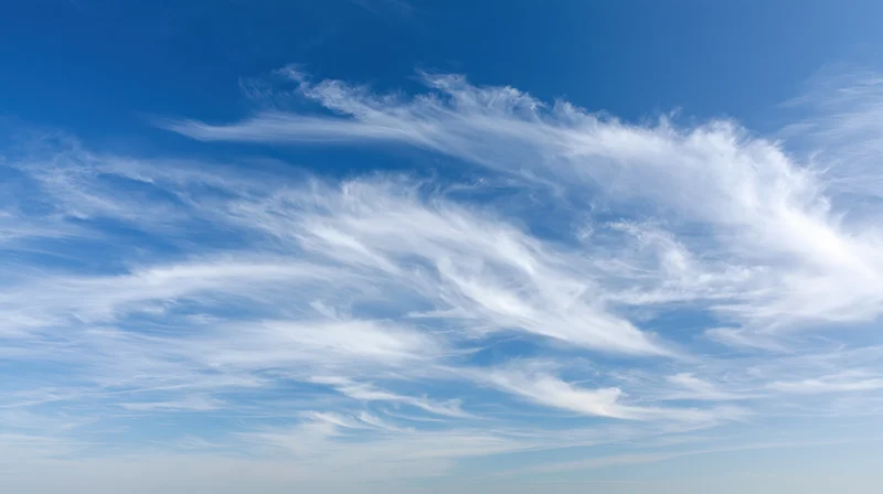 Open blue sky with wispy cirrus clouds scattered across the horizon
