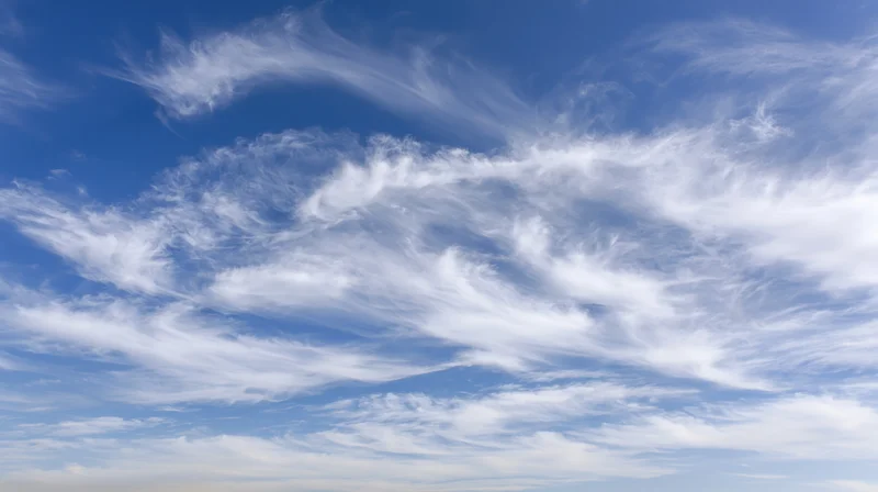 Open blue sky filled with wispy cirrus clouds scattered across the horizon