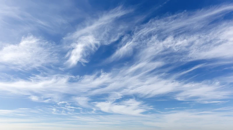 Open blue sky filled with wispy cirrus clouds scattered across the horizon