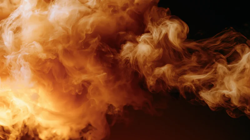 Swirling orange and cream smoke rising against black background