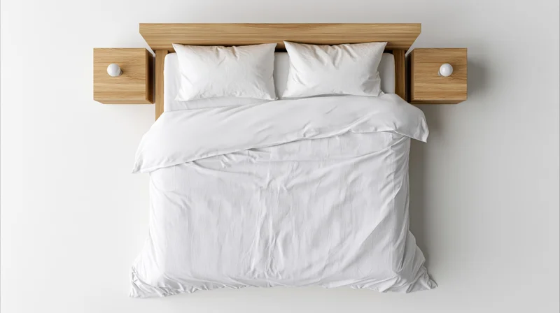 Overhead view of a double bed with white bedding and wooden headboard and nightstands in a minimalist bedroom