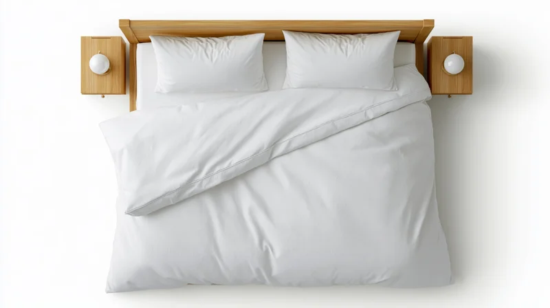 Overhead view of a neatly made double bed with white bedding and wooden headboard and nightstands