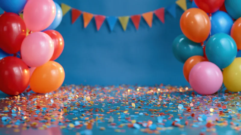 Colorful balloons and confetti scattered on a blue floor with a pennant banner above, creating a festive party scene with copyspace in the center