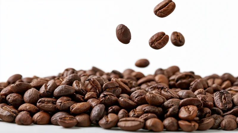 Roasted coffee beans falling midair onto a pile against a white background