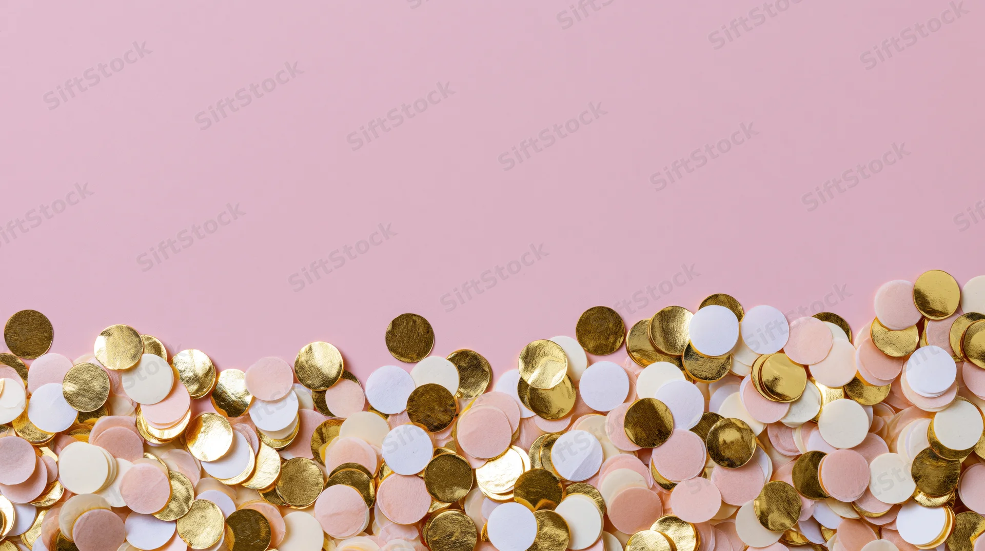 Scattered round confetti in gold, white and pale pink on a pink background with copyspace