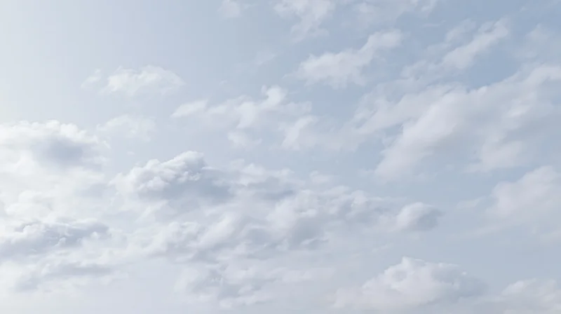 Scattered cumulus clouds drifting across a wide open sky
