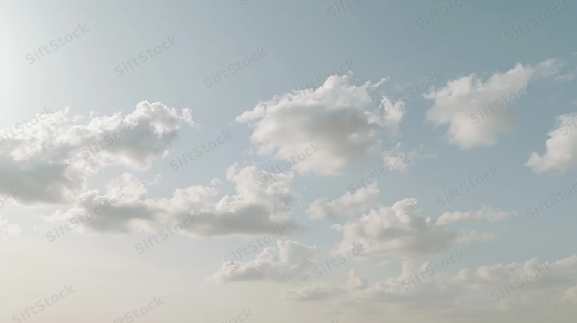 Scattered cumulus clouds drifting across a wide open sky