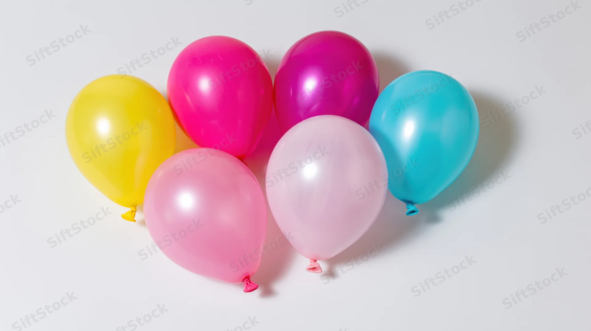 Seven inflated latex balloons clustered together on a white surface