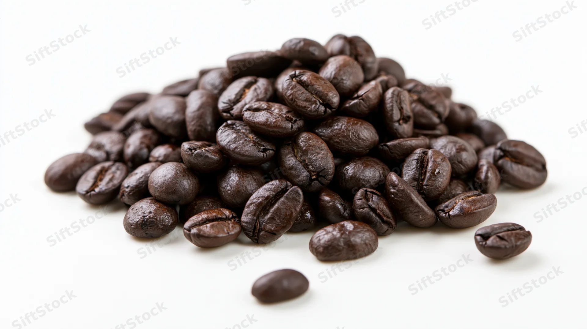 Pile of dark roasted coffee beans scattered on white background