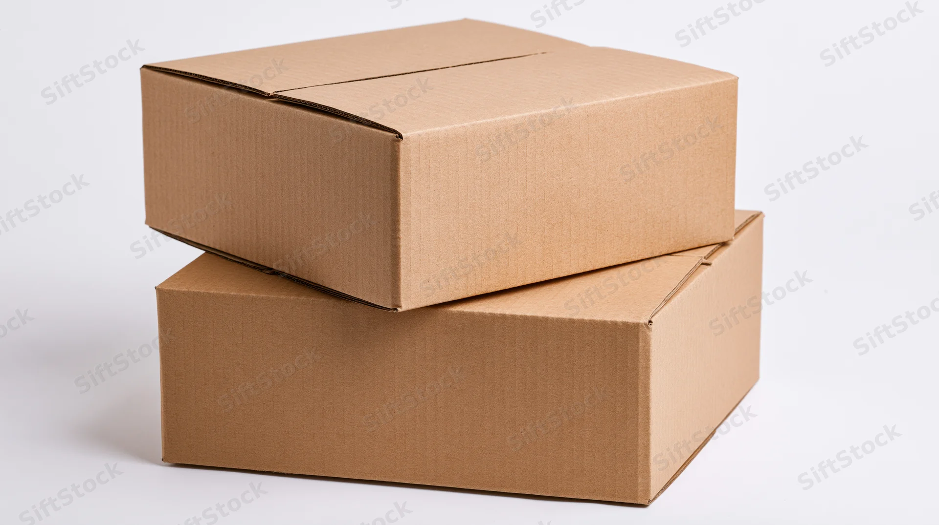 Two plain brown corrugated cardboard shipping boxes stacked on a white surface
