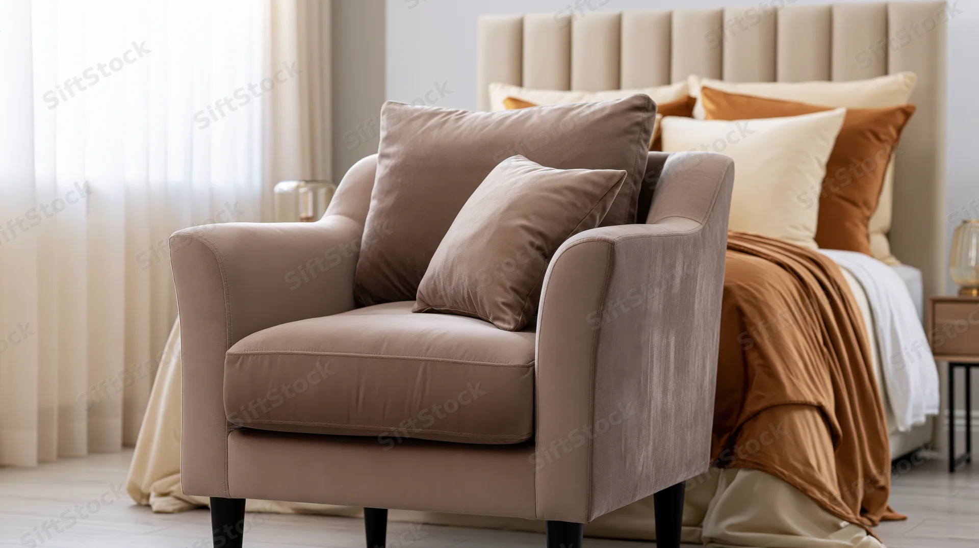 Taupe velvet armchair with cushions in a bedroom setting