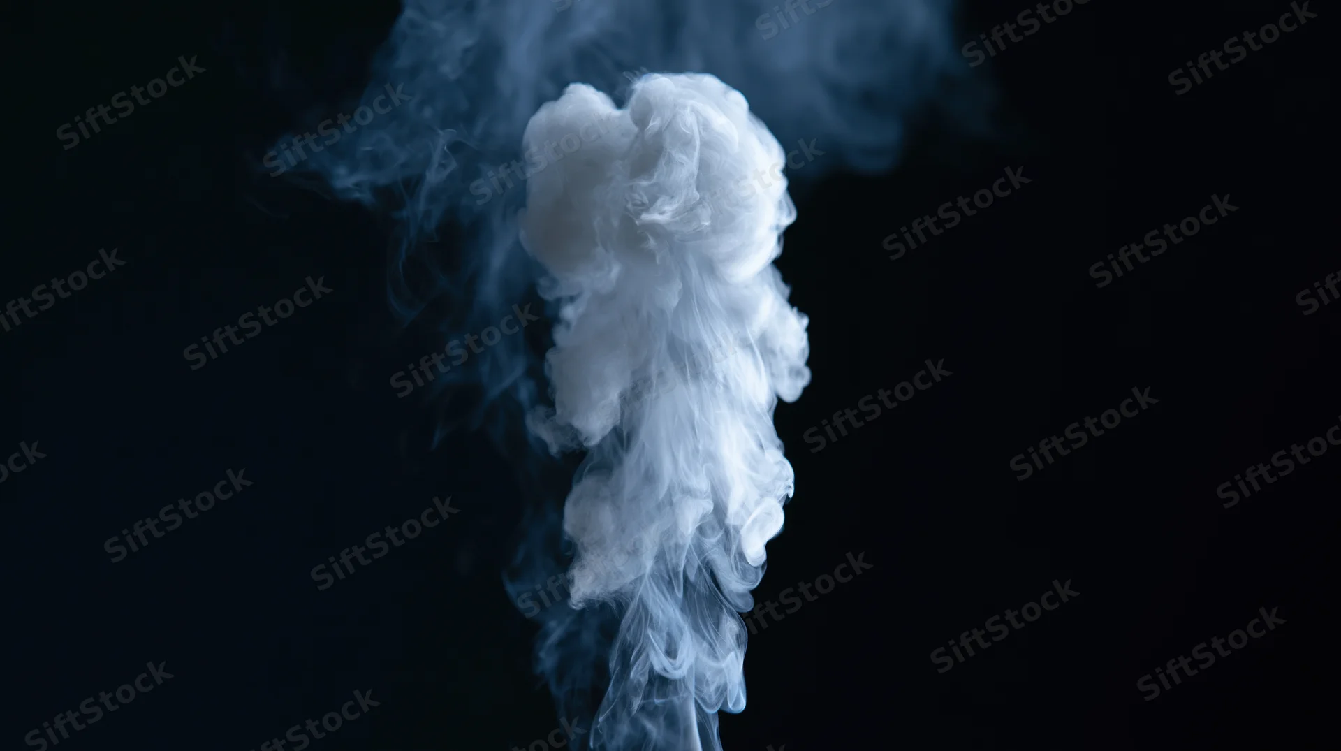 White smoke rising and curling upward against a black background