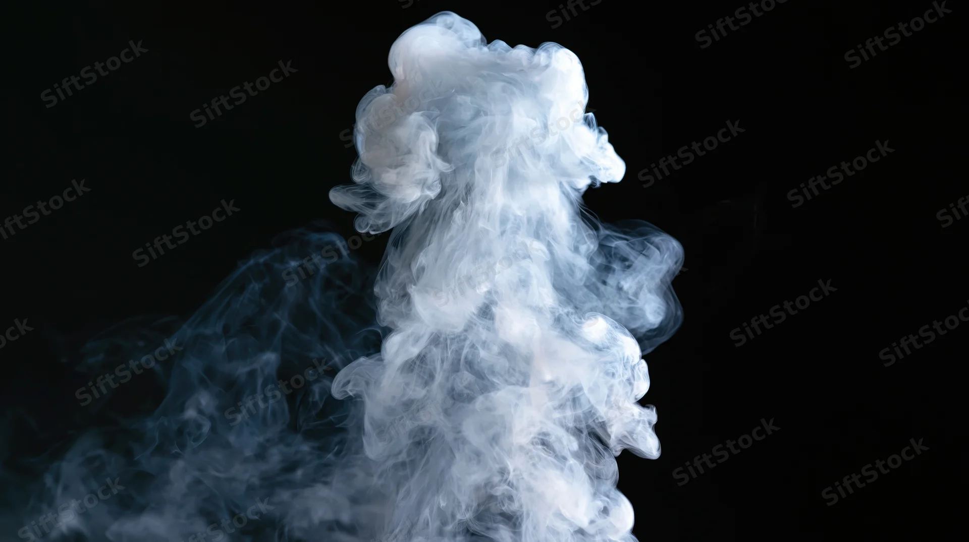 White smoke rising and curling upward against a black background