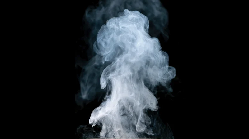 White-grey smoke rising and curling upward against a pure black background