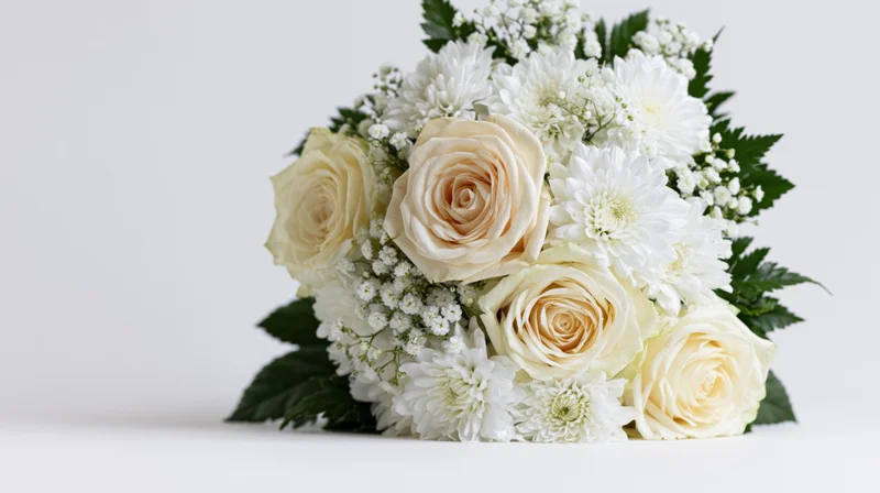 White rose and chrysanthemum bouquet with baby's breath and green leaves on white background