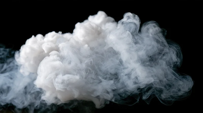White smoke drifting and curling mid-air against a pure black background