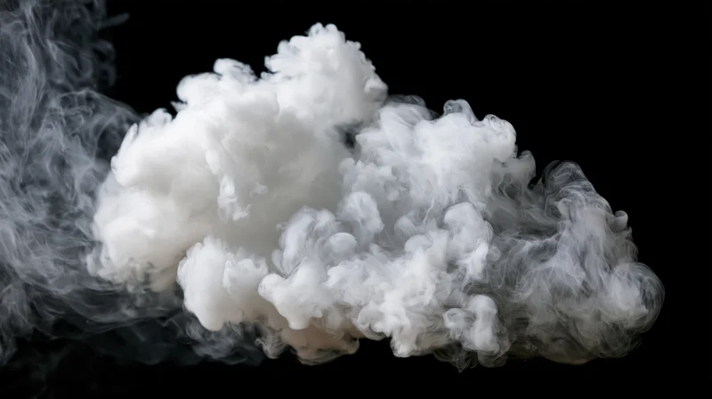 White smoke drifting and curling mid-air against a pure black background