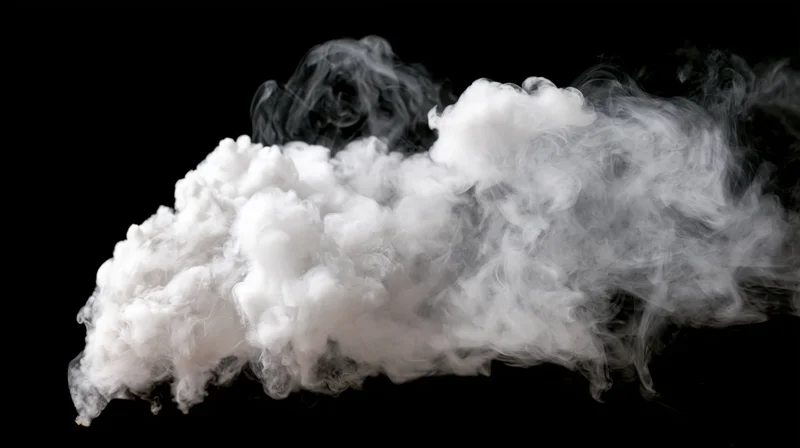 White smoke drifting and curling mid-air against a pure black background