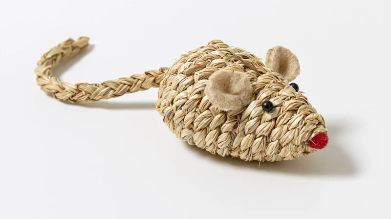 Woven seagrass mouse toy lying flat on white background