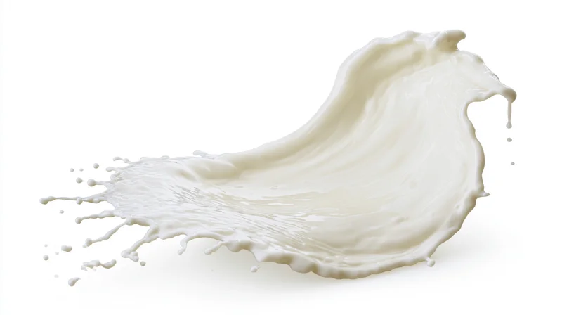 Dynamic swirling splash of white milk frozen mid-motion against white background