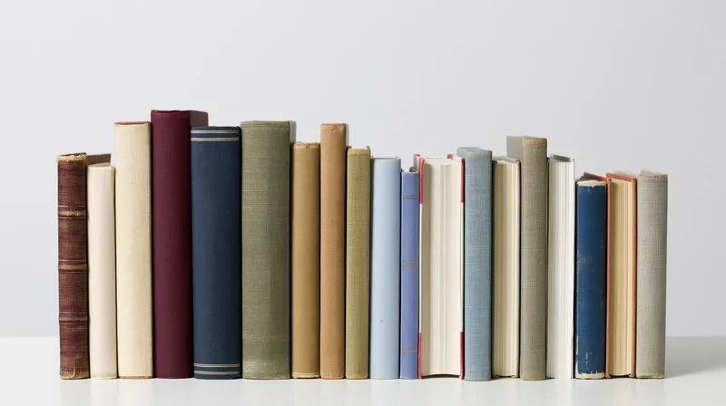 Row of vintage books standing upright on a white surface