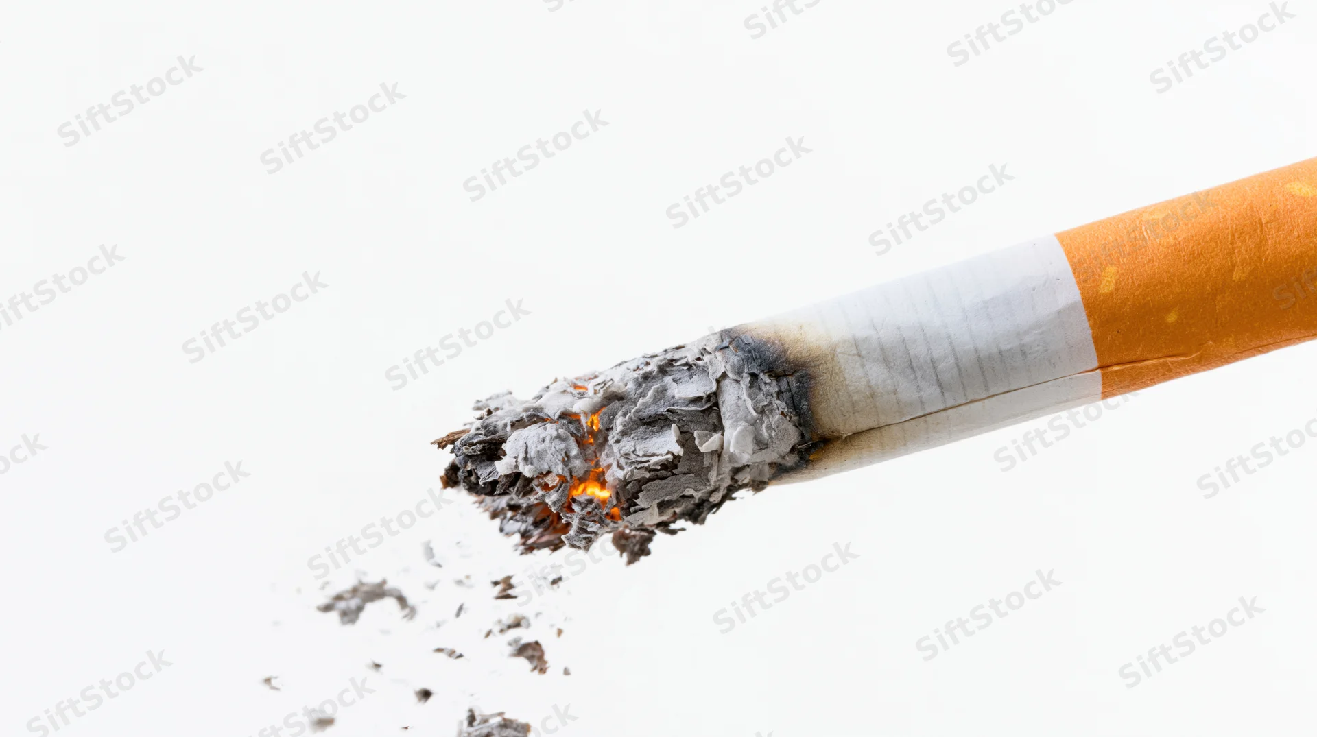 Lit cigarette with burning tip and falling ash on white background