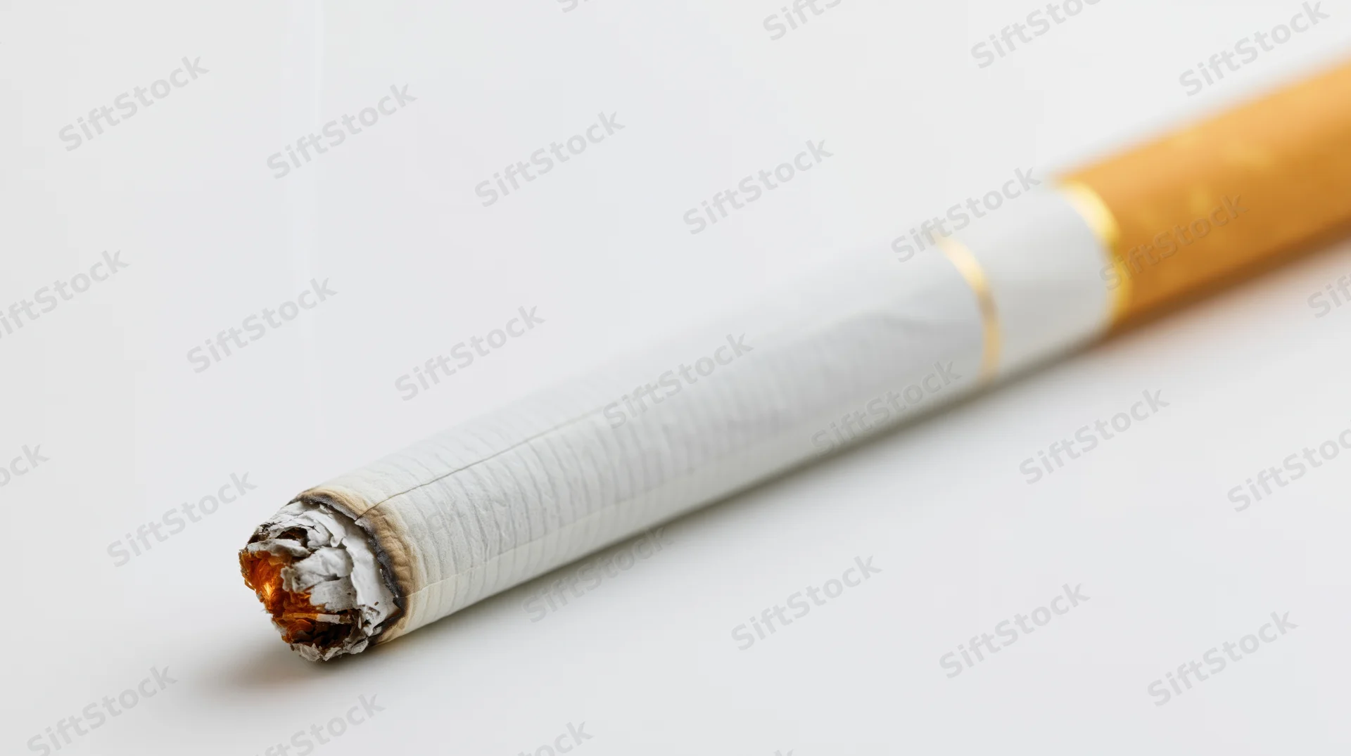Lit cigarette with glowing ember and ash on white background