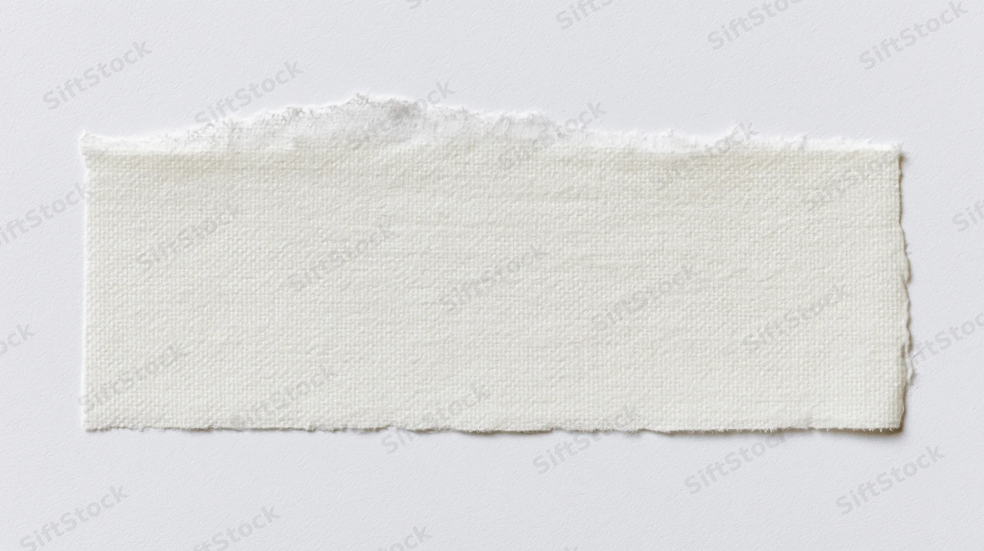 Torn strip of white adhesive tape on a plain surface