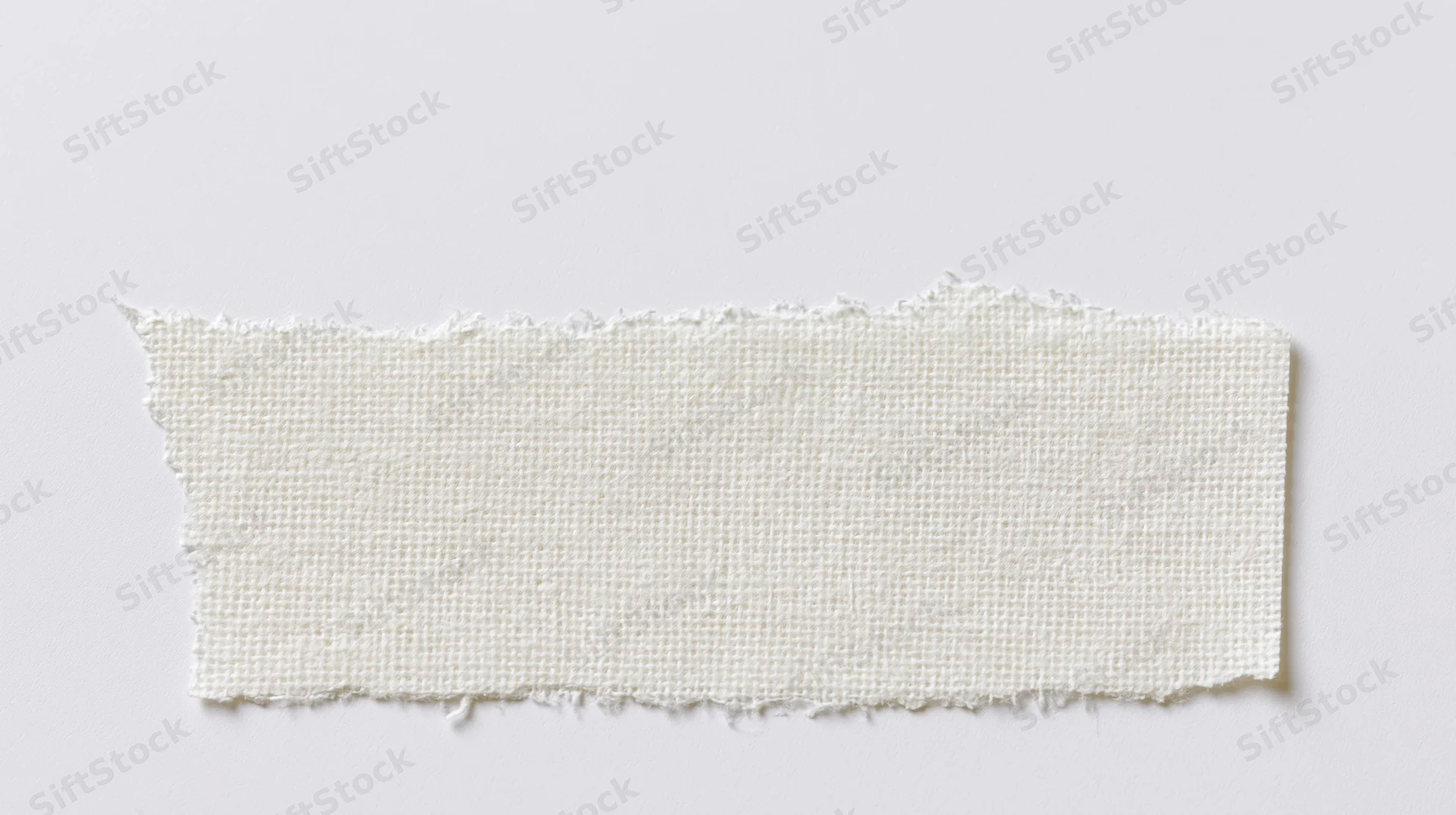 Torn strip of white adhesive tape on plain surface