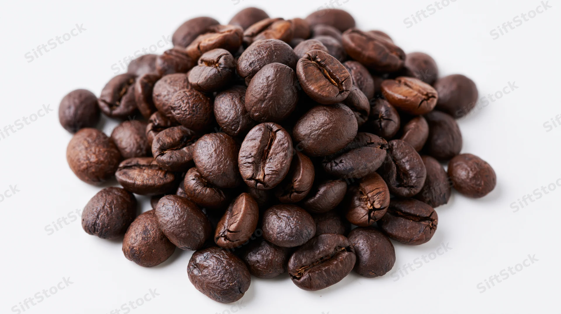 Dark roasted coffee beans piled on white background