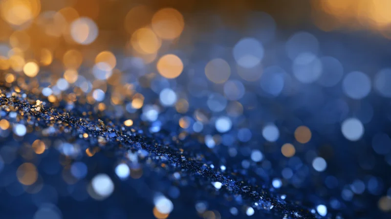 Abstract bokeh background with scattered soft glowing orbs of golden and blue light