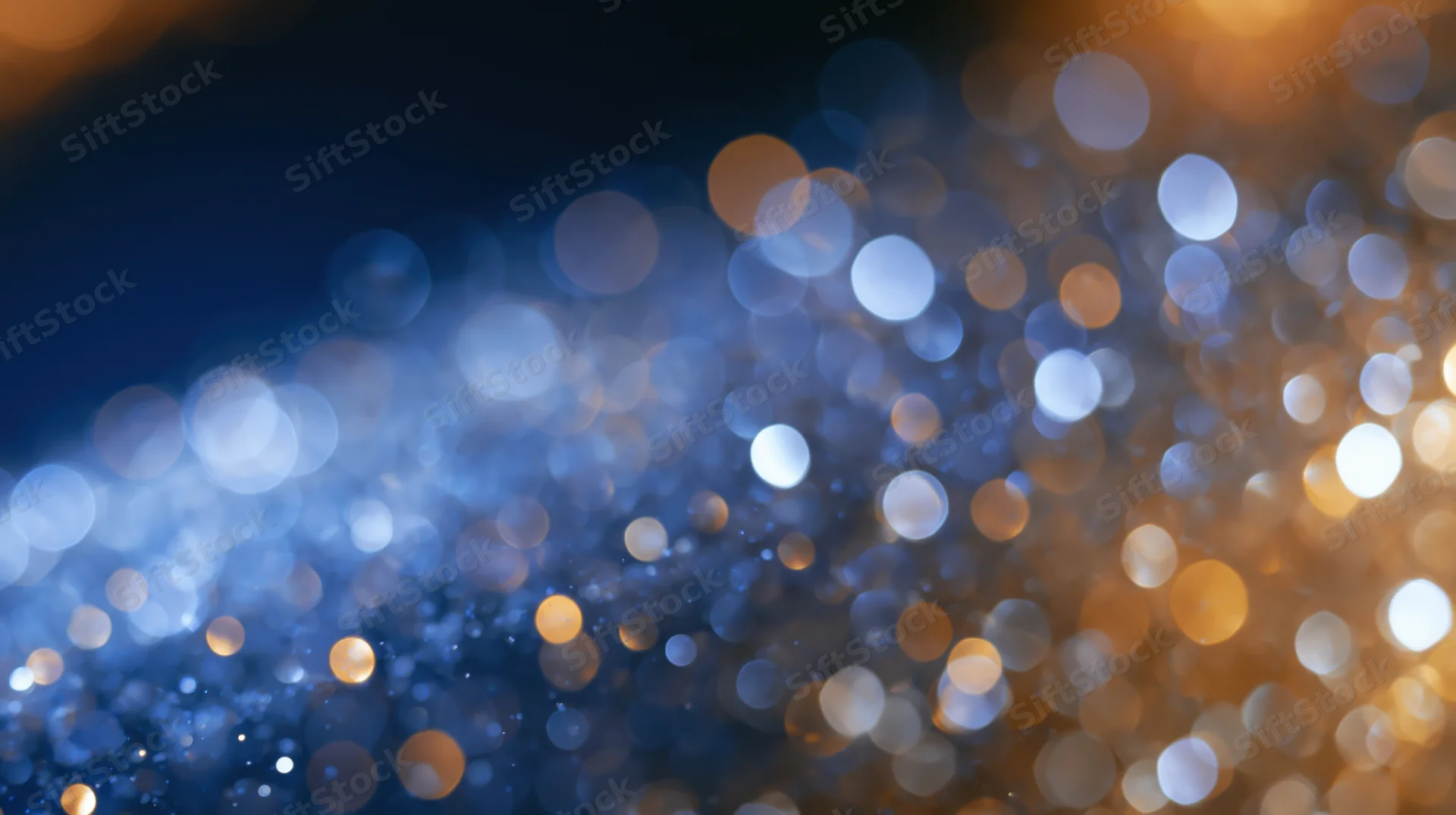 Abstract bokeh background with soft glowing orbs of blue and golden light
