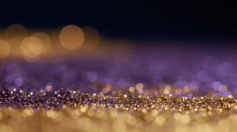 Scattered gold and purple glitter on a studio floor with bokeh lights in the background