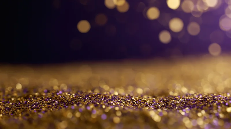 Gold and purple glitter scattered on a studio floor with bokeh lights in the background