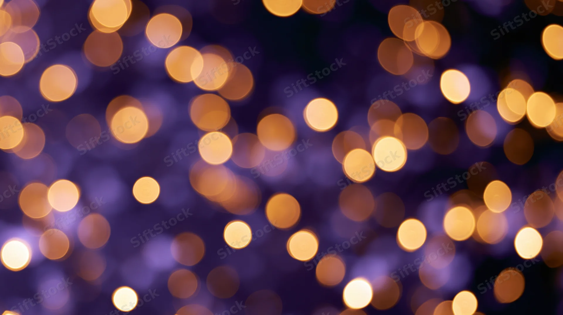 Abstract bokeh background with scattered golden lights on purple blur