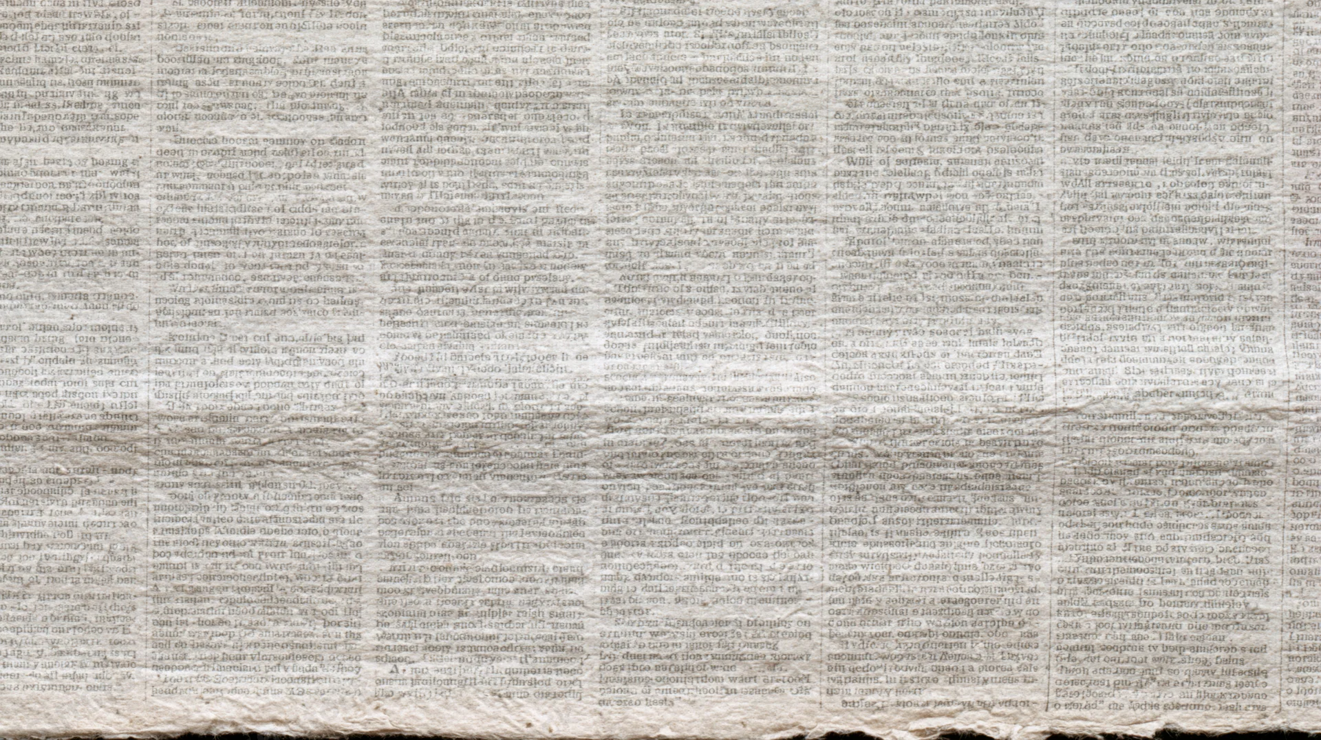Aged newspaper texture filling the frame with multiple columns of printed text
