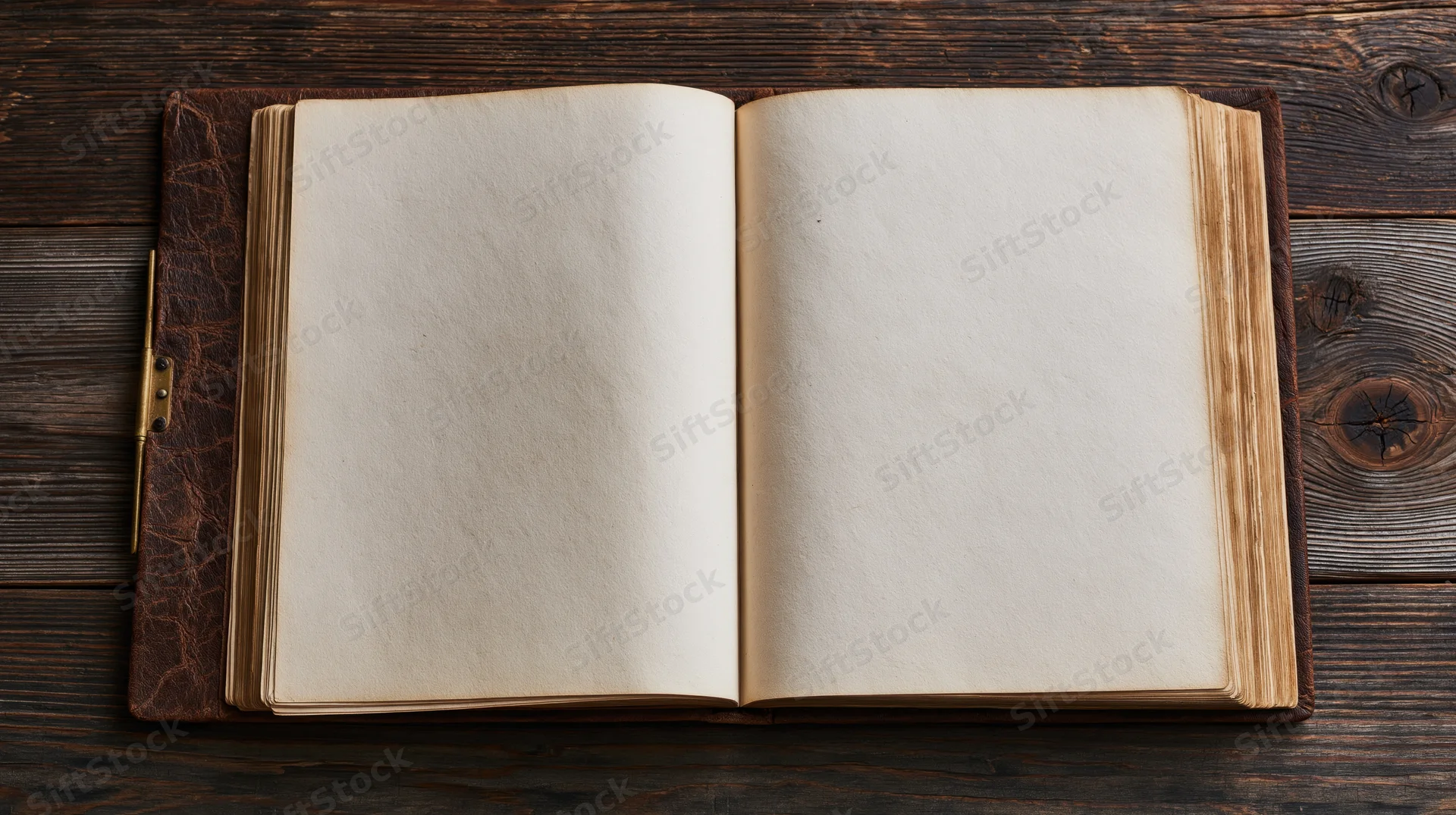 Open vintage leather-bound book with blank yellowed pages on dark wooden surface