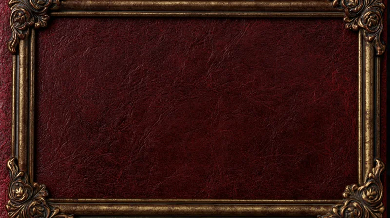 Close-up of an ornate gold frame surrounding a deep crimson textured leather book cover