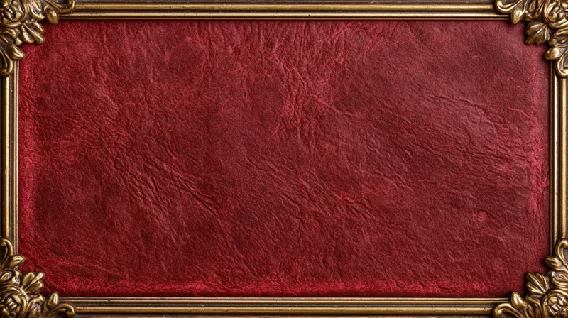Ornate gold frame enclosing deep red textured leather book cover with floral corners
