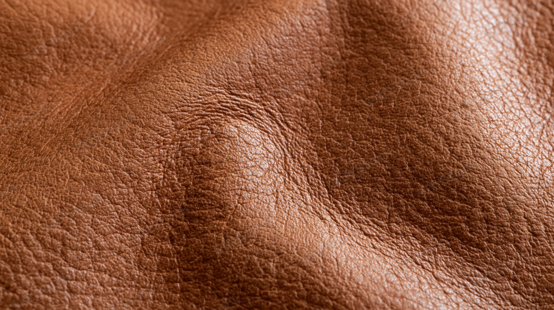 Close-up of tan cognac leather surface showing natural grain and texture