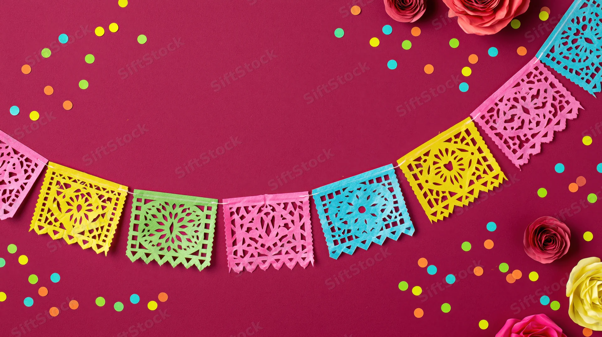 Colorful papel picado banner flags arranged in an arc with confetti and roses on a magenta background