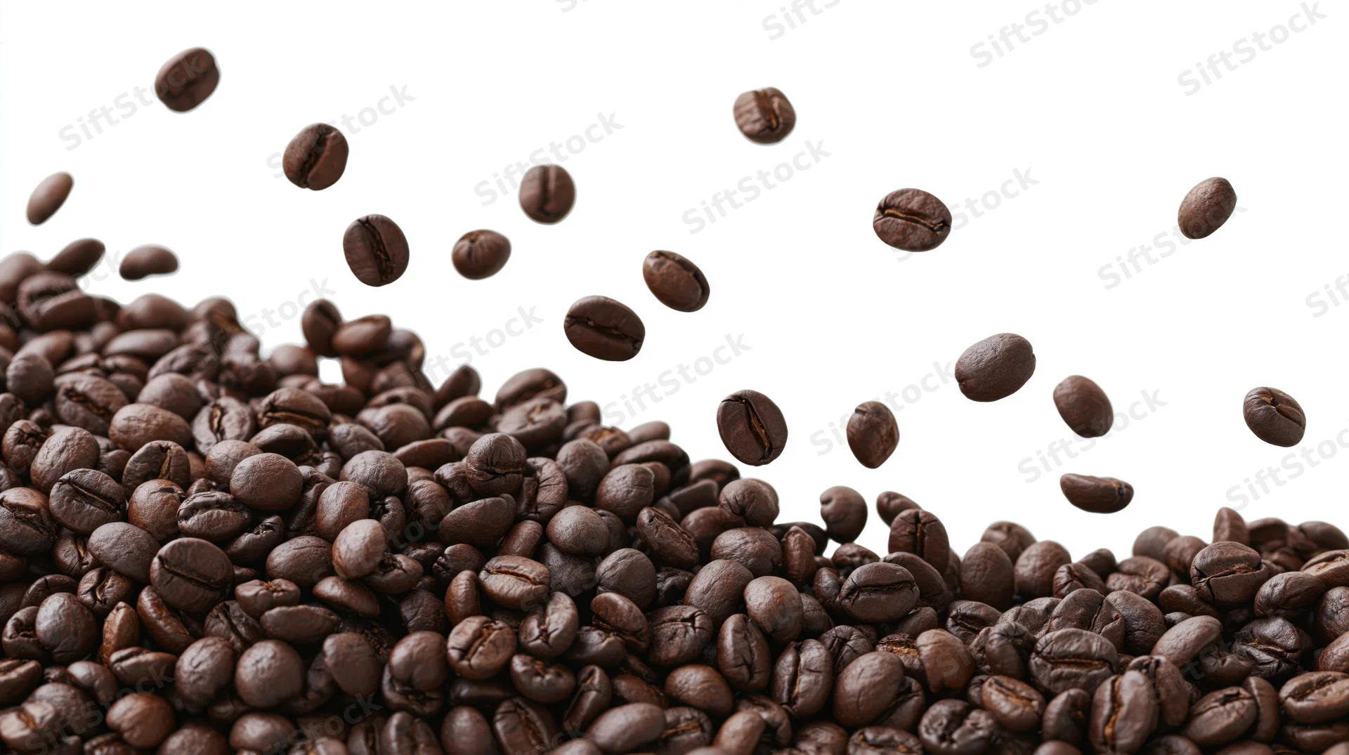 Dark roasted coffee beans falling and scattered in a pile against a white background